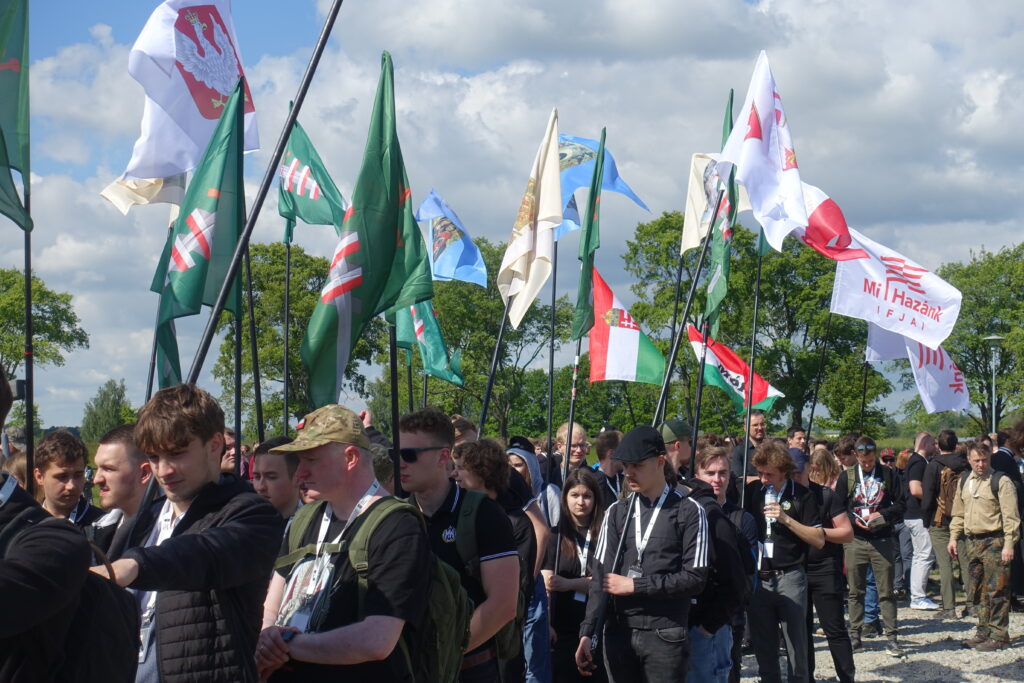 Uczestnicy Pielgrzymki Kościoła Walczącego z flagami narodowymi i religijnymi, w tym banerem węgierskiej organizacji Mi Hazánk Ifjai.